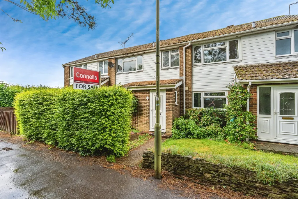 Front view of a 3-bedroom semi-detached house in Romsey with green hedges and a “For Sale” sign.