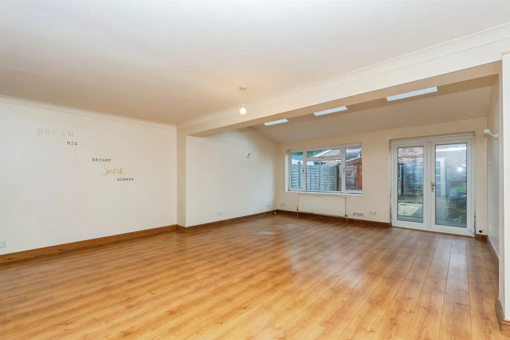 Lounge with wooden floors, French doors, and roof windows looking onto the garden.